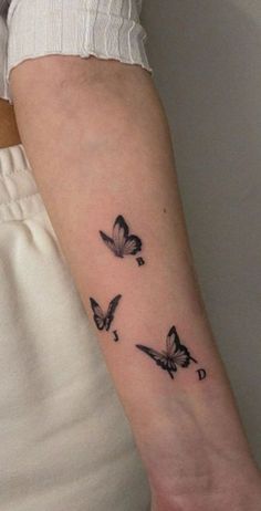 a woman's arm with three butterflies on the left side of her arm,