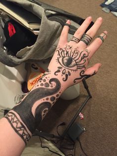 a woman's hand with tattoos on it and an eye tattooed on the wrist