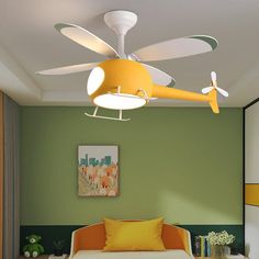 the ceiling fan is yellow and white in this living room with green walls, orange couches, and a painting on the wall