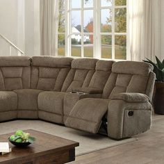 a living room with a large sectional couch and coffee table in front of the window