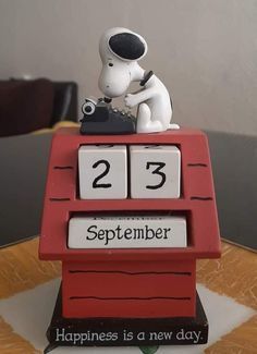 a small figurine sitting on top of a wooden table next to a clock