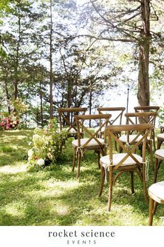 wooden chairs and tables in the grass near trees