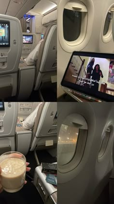 the inside of an airplane with two pictures of people on it and a drink being held up by someone's hand