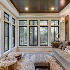 a living room filled with lots of furniture and large windows above it's doors