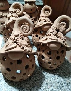 several clay vases sitting on top of a marble counter next to each other in the shape of flowers and leaves