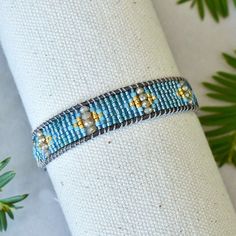 Native American inspired leather wrap bracelet - Natural gray genuine leather cord - Gray silk cord - Brass button - 24K gold glass beads - Other glass beads. Adjustable with 3 loops to fit the gold metal button. 9in long and .5in wide. Beading Jewelery, Seed Beading, Seed Bead Patterns, Siesta Key, Gray Silk, Silk Cord, Western Leather, Leather Wrap Bracelet, Gold Glass