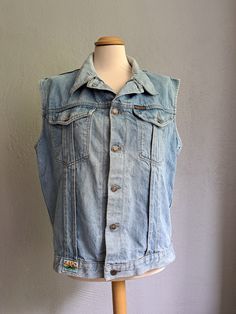 Vintage oversized denim vest Light blue denim vest Button down vest 90s aesthetic clothes Good vintage condition. See the photo. Composition - Cotton Brand - Paradiso. Made in Belgium Size - L Measurements: Length - 63 cm (24.8 in) From pit to pit - 54 cm (21.3 in) All measurements were taken on a horizontal surface. Vintage Sleeveless Denim Jacket For Summer, Vintage Denim Vest With Pockets For Summer, Light Wash Sleeveless Cotton Denim Jacket, Vintage Sleeveless Denim Jacket For Spring, Sleeveless Vintage Denim Jacket For Spring, Retro Style Medium Wash Denim Vest, 90s Style Medium Wash Denim Vest, Blue Denim Vest For Spring In 90s Style, Sleeveless Light Wash Cotton Denim Jacket