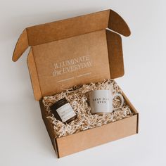 an open box with a coffee mug and some kind of chocolate in it that says illuminate the everyday