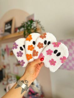 a hand holding four small white and orange patches