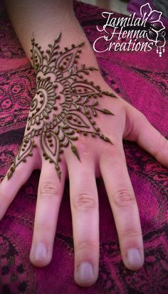 a woman's hand with henna tattoos on it