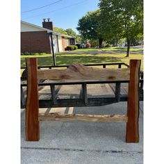 a wooden bench sitting on the side of a road