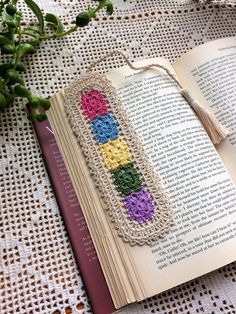 an open book with crocheted beads on it and a tassel hanging from the cover