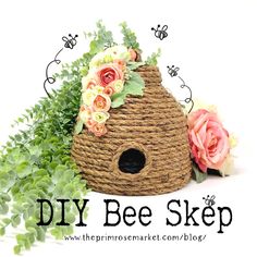 a bird house with flowers and greenery around it's base, on top of the words diy bee skep