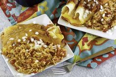 two white plates topped with food on top of a colorful table cloth next to a fork