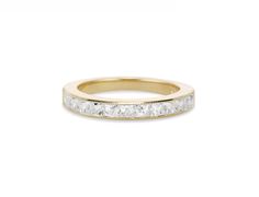 a yellow gold wedding band with three princess cut diamonds on the side, set against a white background