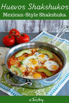 a pan filled with eggs, avocado and tomatoes next to tortillas