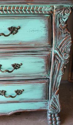 an old blue dresser with ornate carvings on the top and bottom, painted in aqua