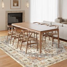 a living room filled with furniture and a rug on top of a hard wood floor