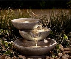 three stone bowls are stacked on top of each other with water pouring out of them