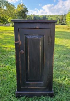 an old wooden cabinet sitting in the grass