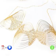 a gold necklace is shown on a white surface with an arrow symbol in the center