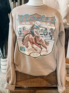 Hand drawn ode to the National Finals Rodeo Sweatshirt. Literally one of the softest sweatshirts you will own. Unisex Fit | Long Sleeve | Crew Neck Bella Canvas Material: 52% Cotton | 48% Polyester Small (2/4) | Medium (6/8) | Large (10/12) | XL (14/16) | 2XL (18/20) Western Graphic Crewneck, Western Long Sleeve Shirts, Western Boutique Ideas Products, Country Sweatshirts Hoodie, Cute Western Outfits Women, Simple Western Outfits, Country Outfit Ideas, Cute Western Outfits, National Finals Rodeo