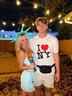 a man and woman dressed up as the statue of liberty, holding a beer bottle