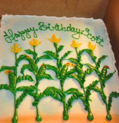 a birthday cake decorated with green and yellow flowers