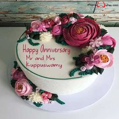 a white cake decorated with pink flowers and the words happy anniversary mr and mrs any name here