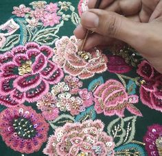 a person is working on an embroidered material