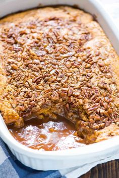 a casserole dish with pecans on top and some sauce in the bottom