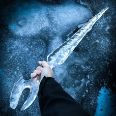 a person holding onto a large knife in the snow