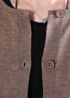 a close up of a person wearing a necklace with buttons on it's collar