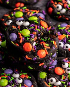 chocolate cookies decorated with sprinkles and candy eyes are arranged on top of each other