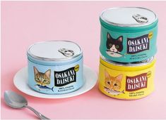 three tins of yogurt with cats on them, one has a spoon