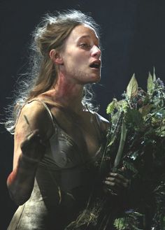 a woman with flowers in her hand on stage