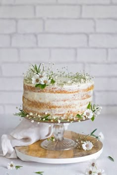 a wedding cake with the name mrs brown on top and flowers around it in front of a brick wall