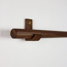 a wooden coat rack on the wall with a yellow button at the top and bottom