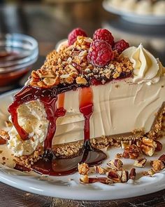 a piece of cheesecake with raspberries and whipped cream on a white plate