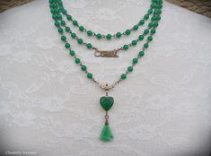 "A gorgeous Jade glass multi strand Art Deco necklace in classic Egyptian Revival style with vintage jade glass beads and cabochons. It makes the perfect handmade women's gift for anyone who loves vintage style Egyptian jewelry. Made from strands of 6mm vintage Cherry brand jade glass beads, a brass Sphinx connector charm, and a 14mm Jade glass heart-shaped scarab with a textured, mixed light and dark Jade glass fan pendant. The smallest row in this necklace measures 15\" closest to the throat, Antique Green Beaded Necklace As Gift, Antique Green Beaded Necklace For Gift, Vintage Double Strand Gemstone Bead Jewelry, Vintage Glass Jewelry With Gemstone Beads, Vintage Double Strand Gemstone Beads Necklace, Handmade Victorian Green Necklaces, Vintage Jade Beaded Necklaces, Vintage Green Pendant Beaded Necklace, Vintage Green Double Strand Necklaces