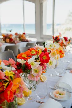 a long table is set with flowers and plates