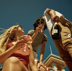 three people are drinking wine outside together