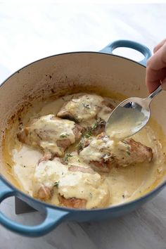 a person is spooning some food out of a pot with gravy on it