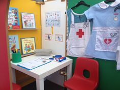 a child's hospital room with toys and books on the wall, including a desk