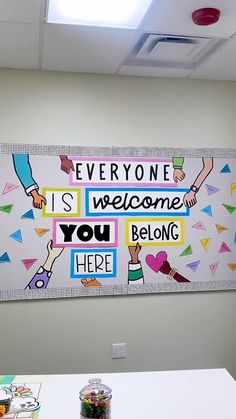 there is a sign that says everyone is welcome you belong here on the wall in an office