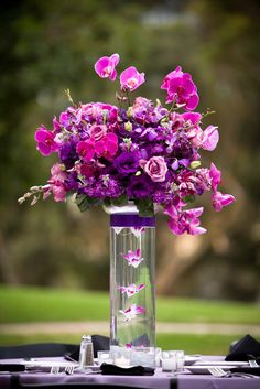 a vase filled with purple flowers on top of a table