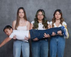 three women and a boy are posing for the camera with their arms wrapped around each other