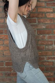 a woman leaning against a brick wall with her hand on her head, wearing jeans and a white t - shirt