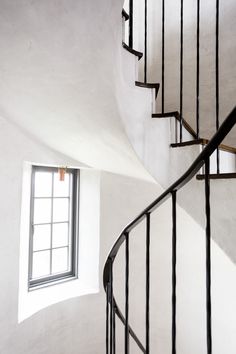 a spiral staircase with a window in the corner