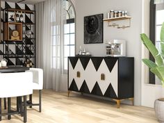 a black and white sideboard in a dining room with two chairs, a potted plant and pictures on the wall